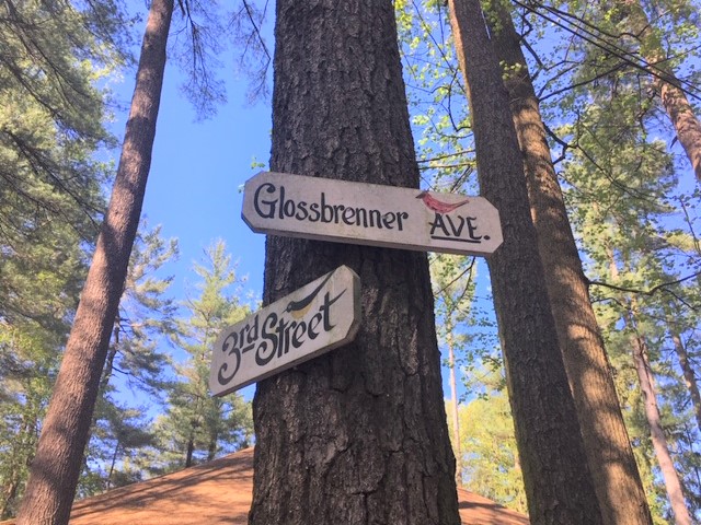 Hand-painted street signs for Glossbrenner Avenue and Third Street, nailed to a tree